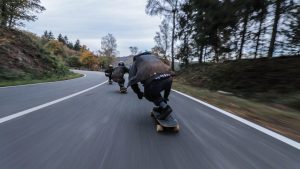 Longboard riders moving at speed on a road