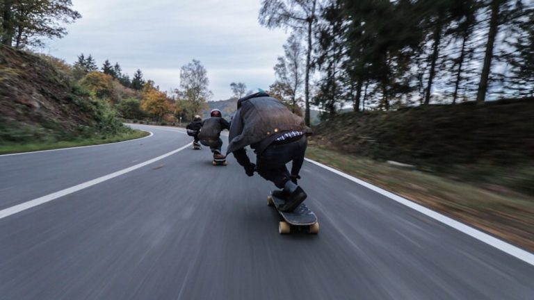 Longboard riders moving at speed on a road