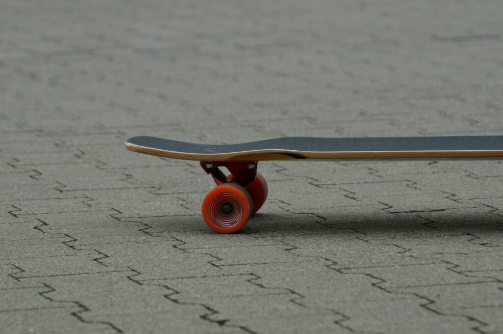Board with red wheels resting on the ground
