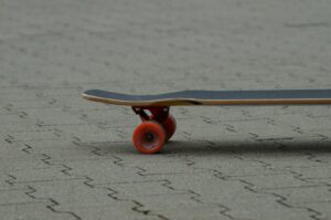 Board with red wheels resting on the ground