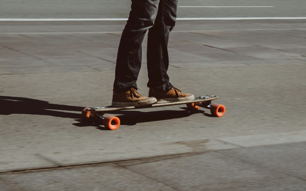 Rider cruising and carving on a longboard on a sunny city street